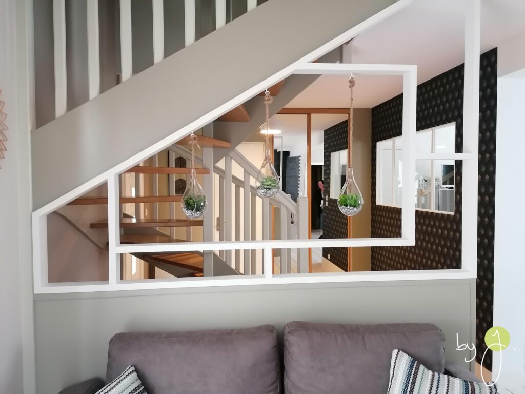 Décoration et agencement d'une entrée avec réalisation d'une ouverture entre la cuisine à l'entrée pour apporter de la lumière naturelle. Design d'un claustrat pour séparer l'entrée de l'espace salon tout en gardant un espace ouvert. Conseils et accompagnement dans le choix d'un papier peint géométrique pour apporter de la personnalité et un rendu sophistiqué à cette entrée, pour se projet réalisé à Gévezé