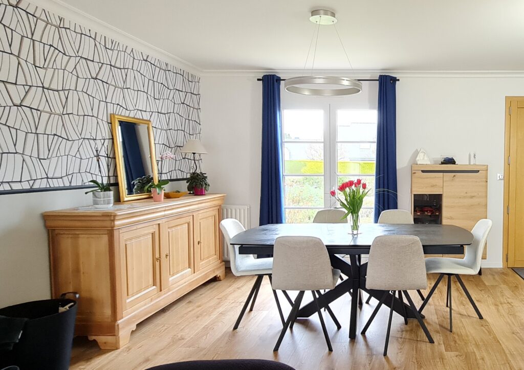 Rénovation complète de cette pièce de vie du sol au plafond. Remplacement du sol par un stratifié, relooking des meubles dans un soucis écologique et économique par le biais d'une mise en peinture et d'un décapage/ponçage. Les murs ont été repeints et tapissés. Accompagnement dans le choix des voilages et rideaux pour ce projet bleu et blanc avec des touches de noir pour apporter de la finesse à ce projet réalisé à Châteaugiron